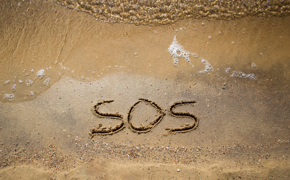 SOS gravé sur le sable